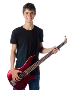 teenager boy with bass guitar smiling