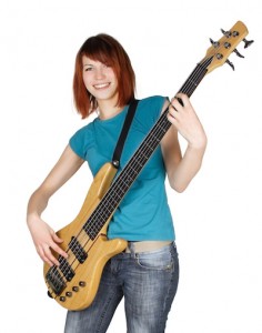 young beauty redhead girl playing bass guitar and smiling, full body, isolated
