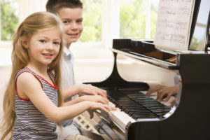 Friends enjoying playing piano together